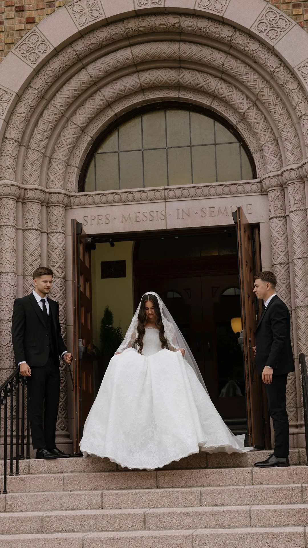 Bride standing in an open church doorway between two groomsmen