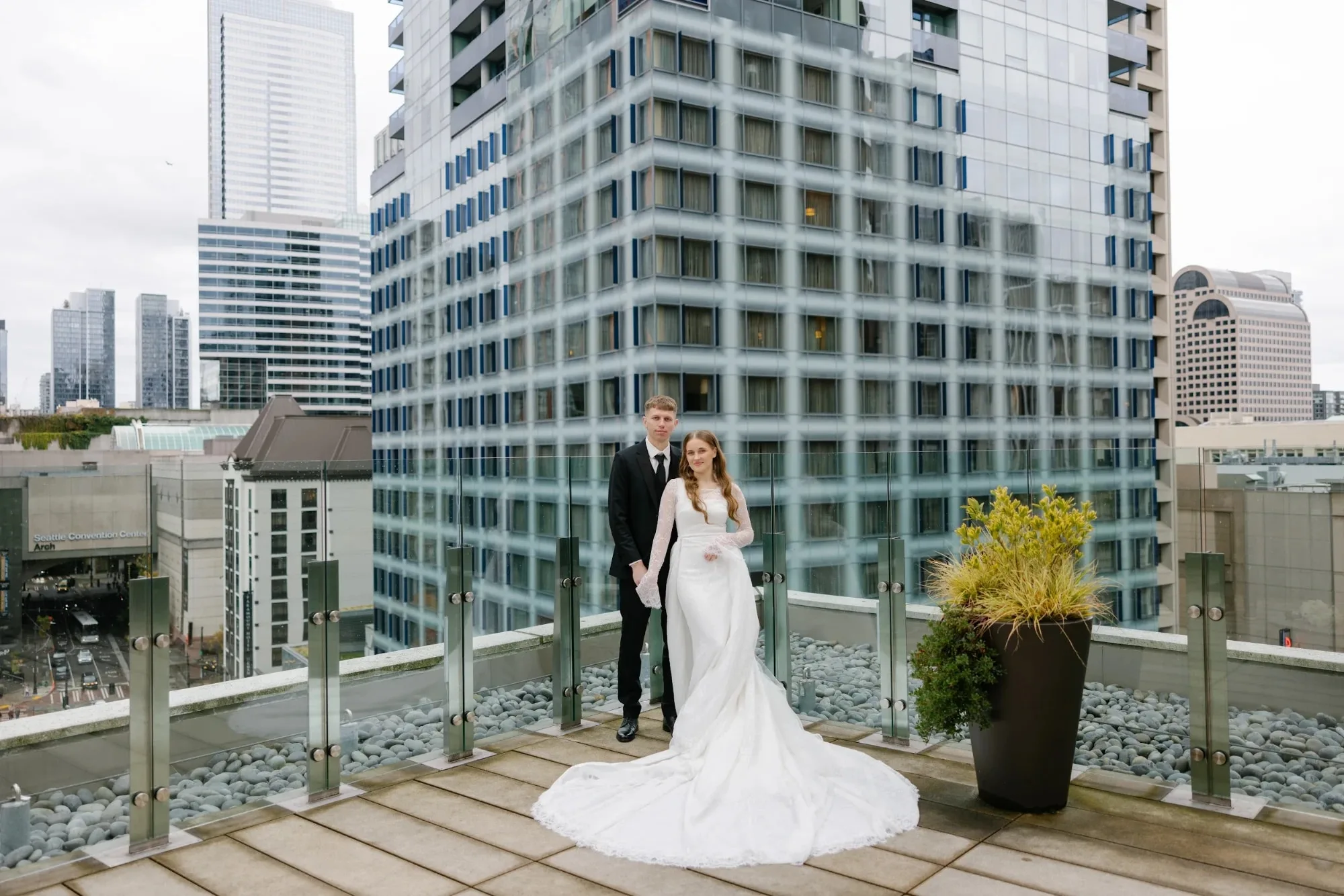 Bride and groom on a downtown Seattle rooftop terrace among glass towers